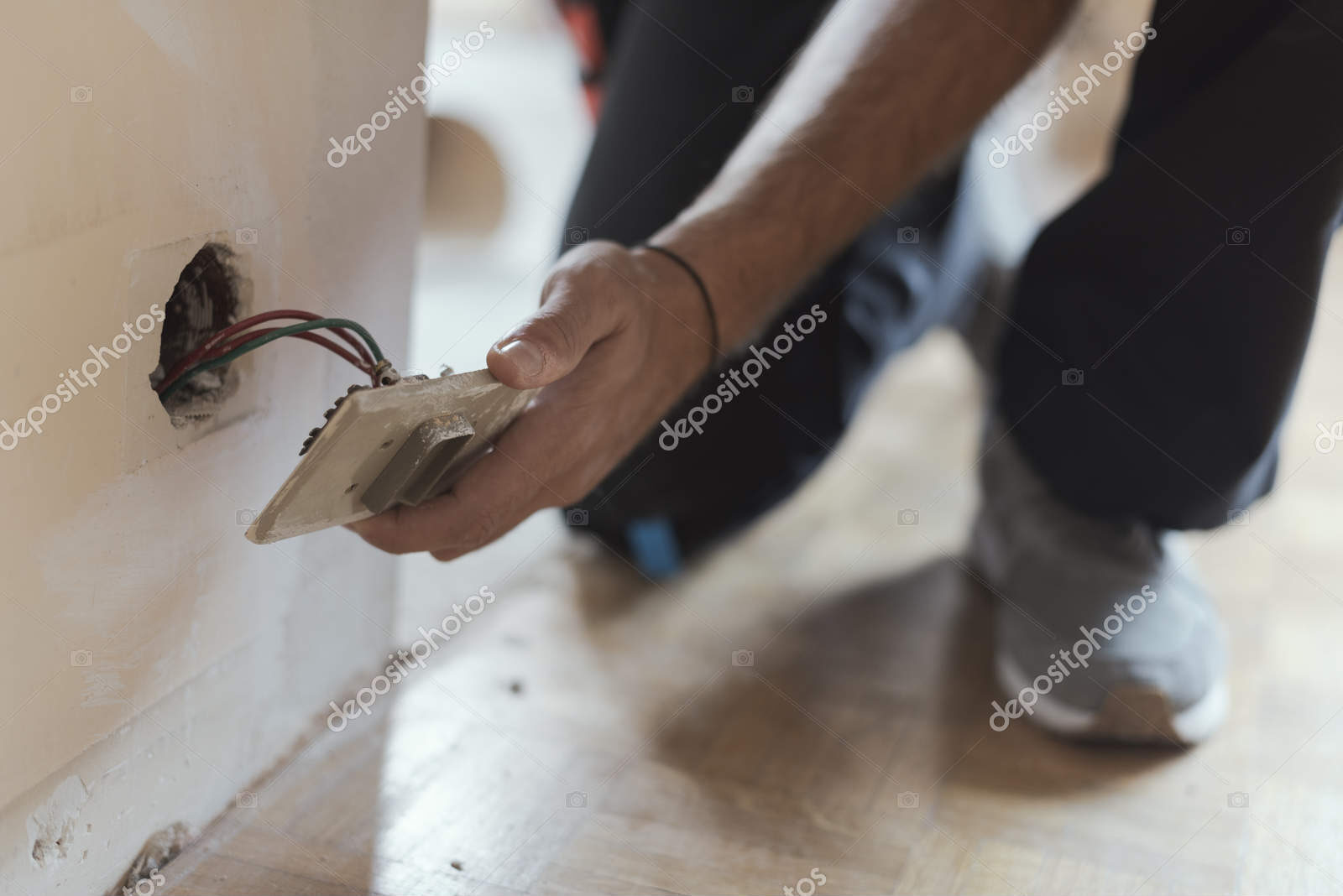 Professional electrician installing sockets using a screwdriver: home renovation and maintenance concept